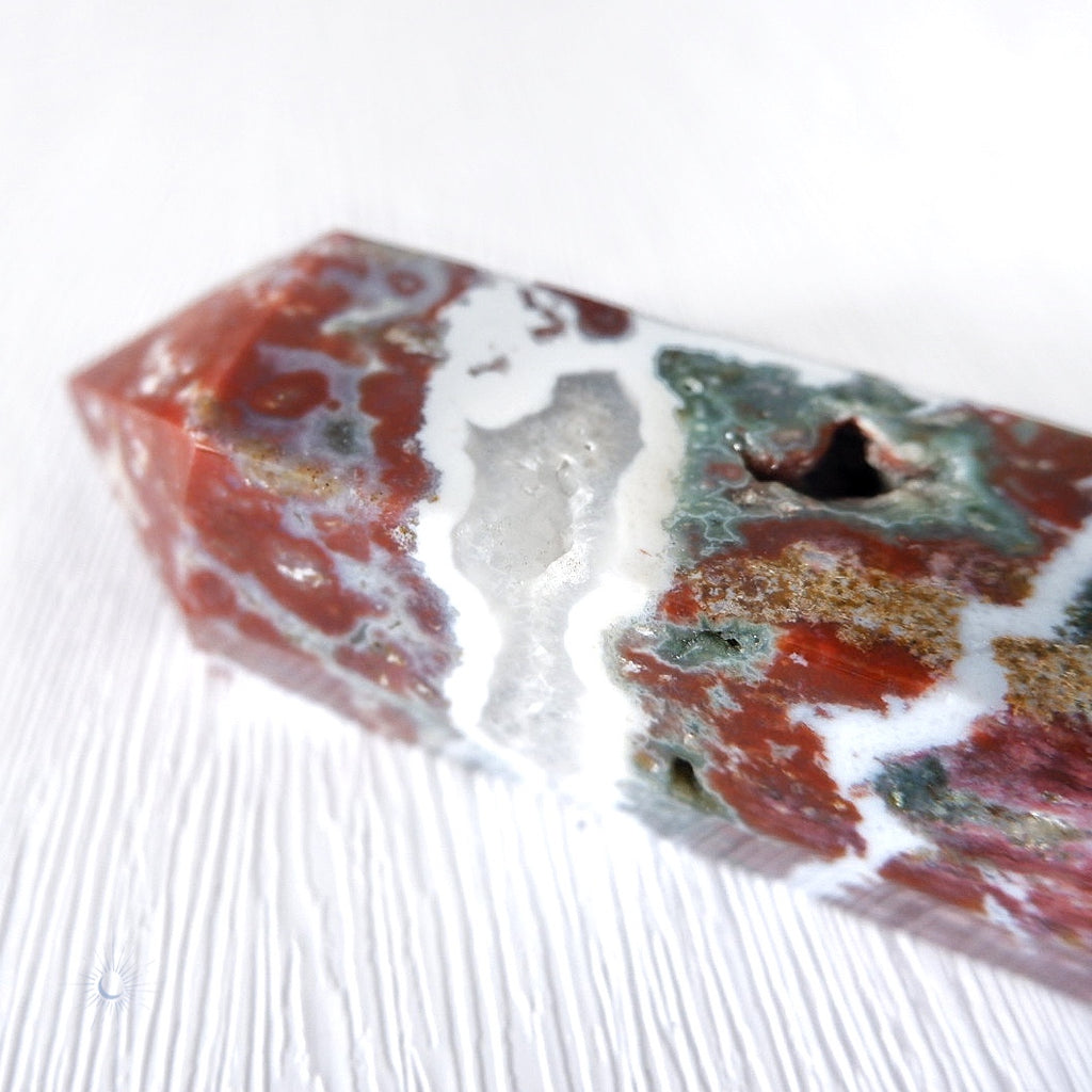 Scenic pink, maroon and green ocean jasper obelisk with druzy and white banding